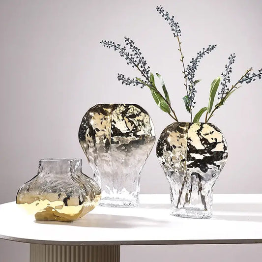 Three modern golden geometric glass vases with hammered metallic finish gold and black accents on clear bases for decorbites golden geometric decor