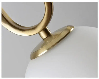 Modern golden glass ball pendant light with a brass-finished metal frame and smooth white globe for kitchen decorbites golden glass