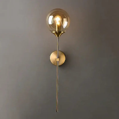 Modern brass-finished wall lamp with a golden glass ball amber globe and exposed filament bulb for bedroom decorbites golden glass