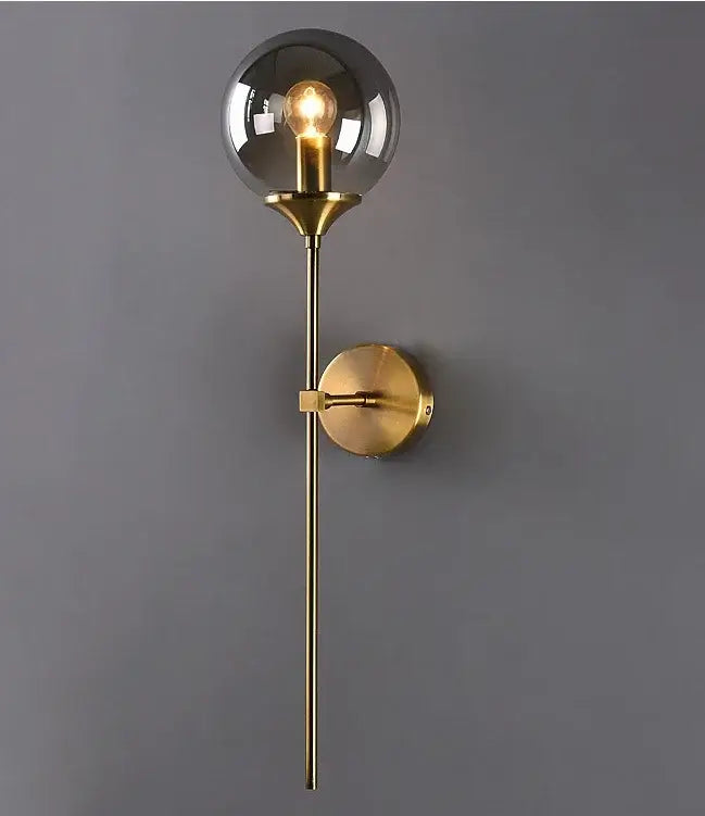 A sleek modern golden glass ball wall lamp with a brass smoked globe sconce and exposed filament bulb for decorbites