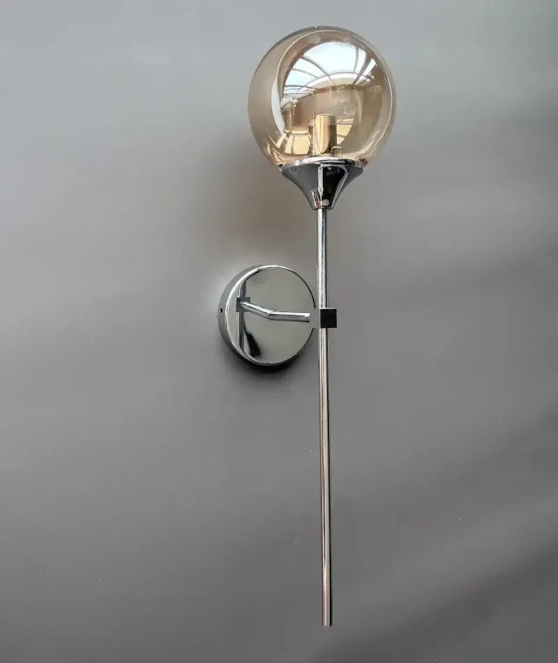 Modern golden glass ball wall sconce with chrome finish, slender stem, and circular mounting plate for living room decorbites lighting