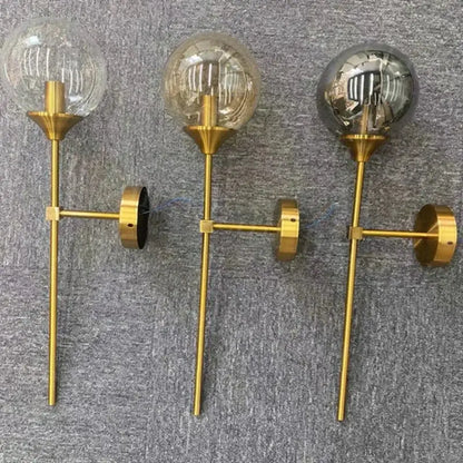 Three gold-toned modern wall sconces with golden glass ball globes and exposed filament bulbs for living room decorbites golden glass lighting