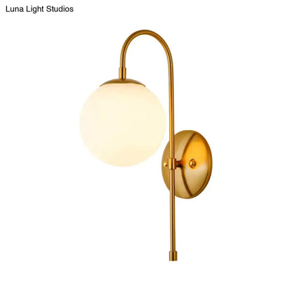 Modern golden gooseneck wall sconce with frosted glass ball shade and curved arm for bedroom lighting