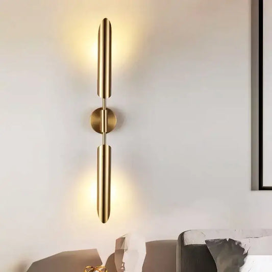Modern golden inclined tube wall lamp with gold-toned cylindrical arms and central base for luxury living room decorbites