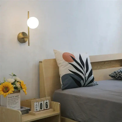 Modern brass wall sconce with spherical white glass shade by decorbites golden indoor wall lights for bedroom decor