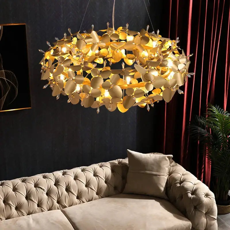 Modern golden leaf crystal firefly ceiling chandelier with crystal accents above a tufted beige sofa for dining room decorbites crystal firefly