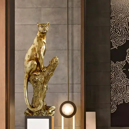Modern decorbites golden leopard resin sculpture with detailed spotted pattern seated on textured tree stump base