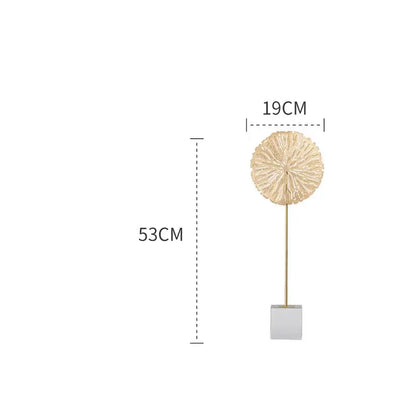 A gold-toned intricately textured metal golden lotus sculpture on a slender stem with square base for living room decor