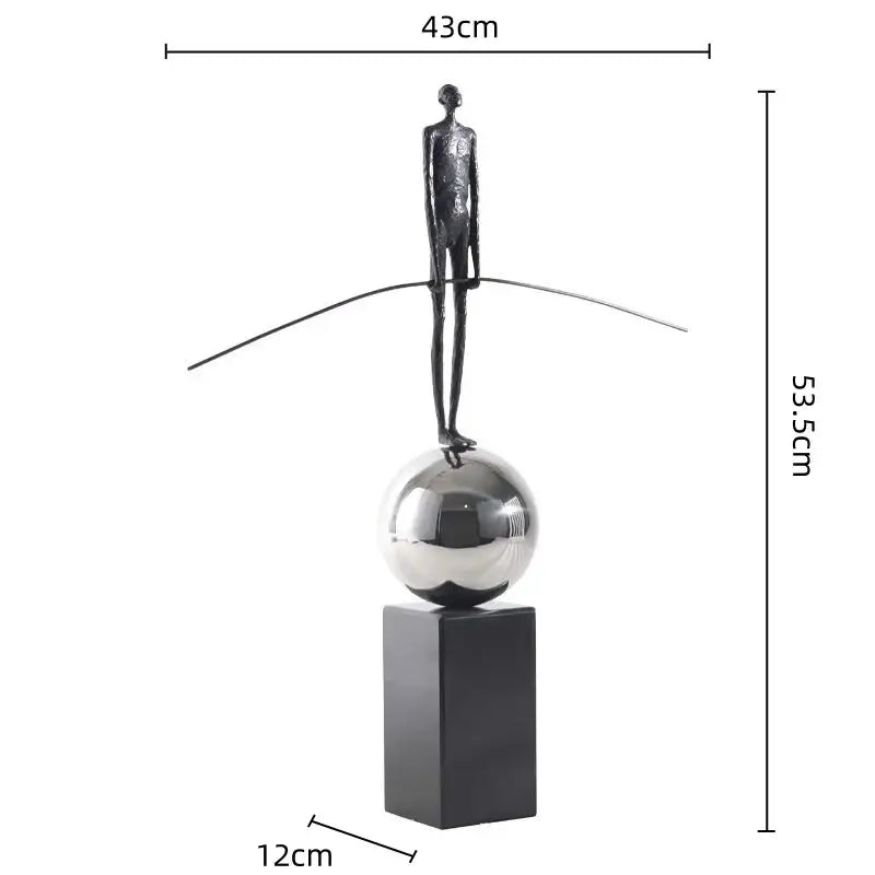 A sleek golden metal abstract figure sculpture on a reflective silver sphere base for modern living room decorbites decor