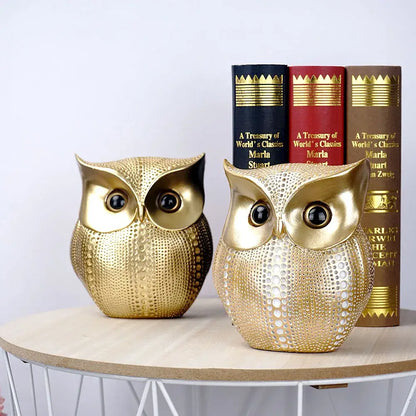 Two modern golden owl figurines with textured perforations and glossy black eyes as decorbites animal statues