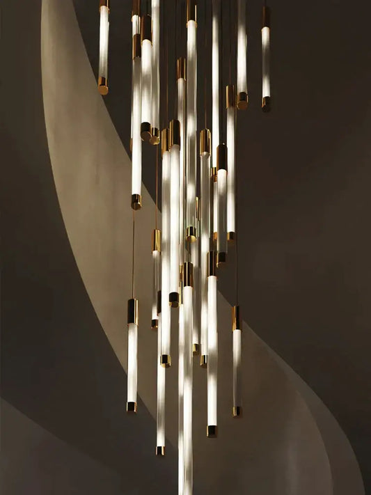 Modern golden tube chandelier with translucent glass tubes and polished gold-toned metal caps by decorbites golden tube