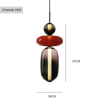Modern glass pendant light with stacked geometric shapes in deep red black and gold for dining room use