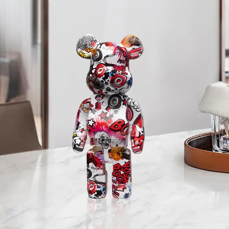 A vibrant decorbites graffiti bear 27cm figurine with glossy white base and bold red black yellow graphics used as money jar