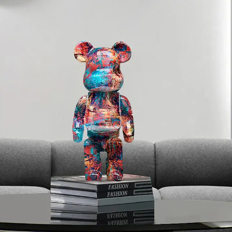 A vibrant glossy modern graffiti bear 27cm figurine with red blue and orange paint splatter used as a money jar decorbites graffiti bear