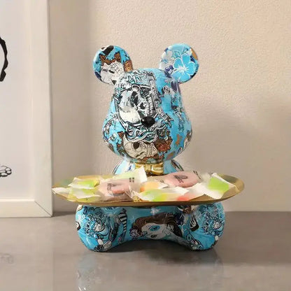A blue bear figurine with detailed tattoo-style artwork and a glossy finish on a golden tray for living room decorbites graffiti bear