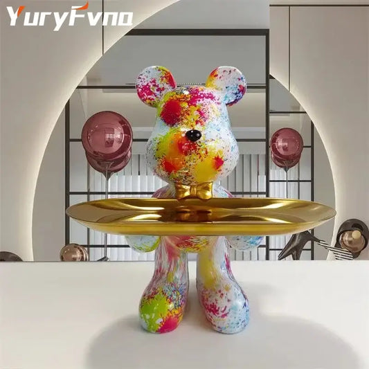 A vibrant splatter-painted bear statue ornament with a glossy finish and gold tray for modern home decor
