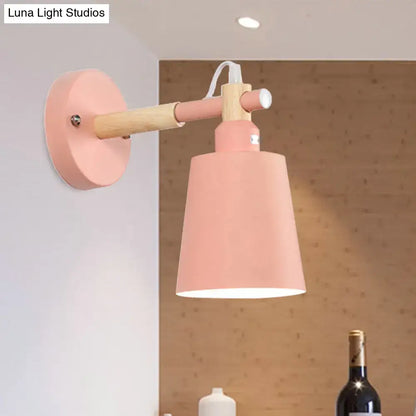 Modern gray and wood wall sconce light with pastel pink conical shade and wooden arm for bedroom use
