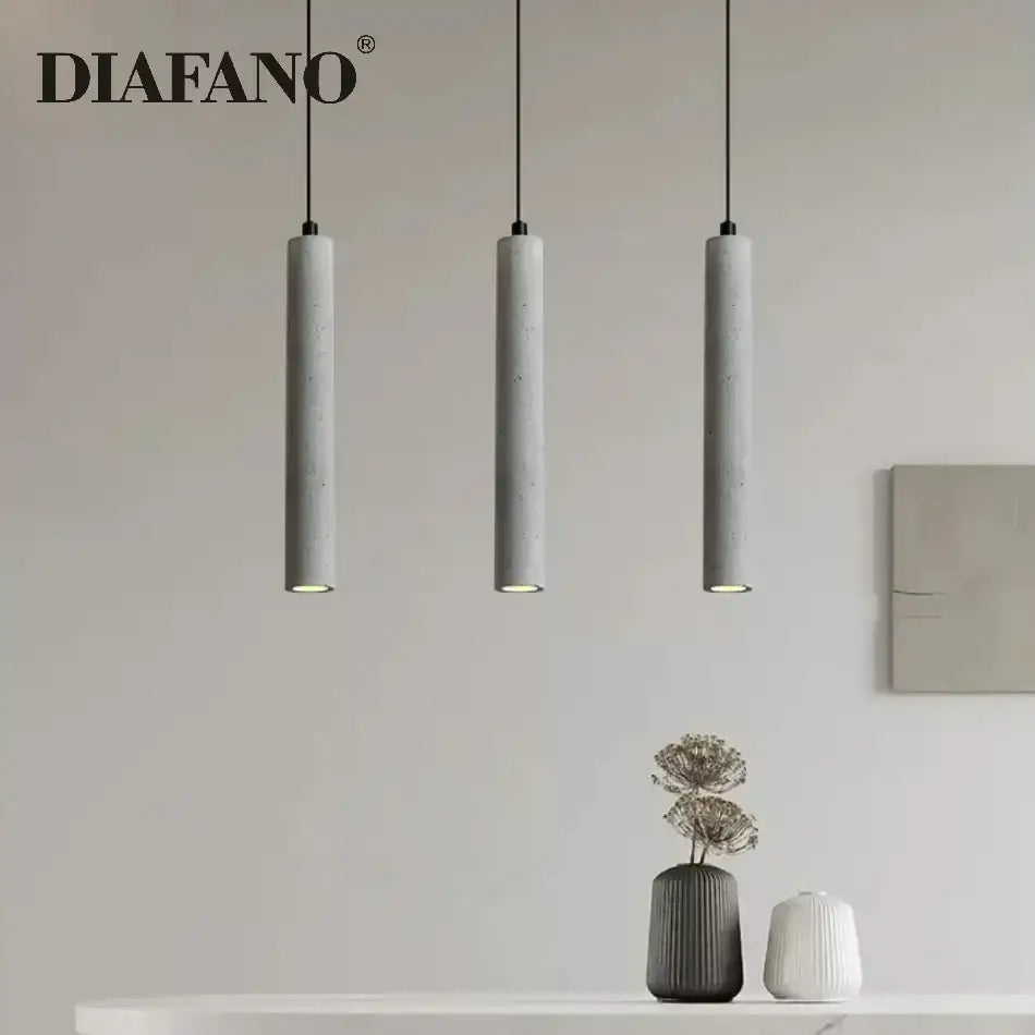 Modern gray concrete tube pendant light with three sleek cylindrical shades hanging from black cords for dining room decorbites concrete tube pendant
