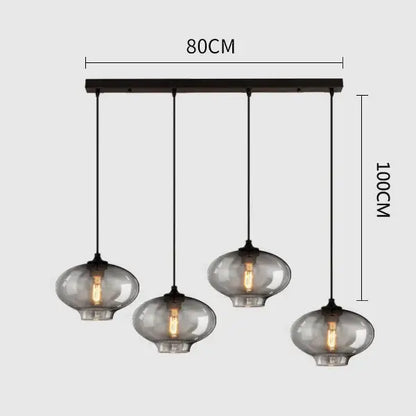 Modern black metal pendant light with four hanging smoked gray glass globes ideal for dining room lighting