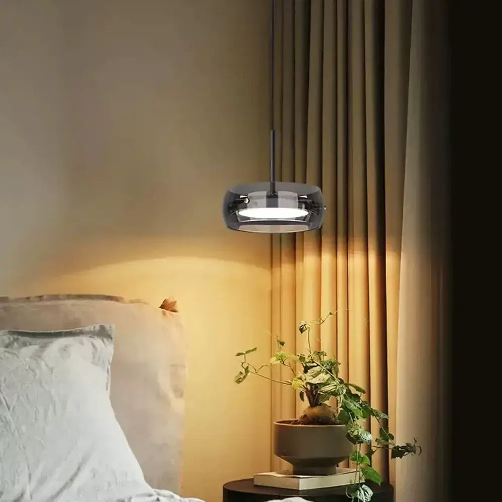 Modern black pendant light with sleek circular gray glass shade and plated detailing for kitchen lighting