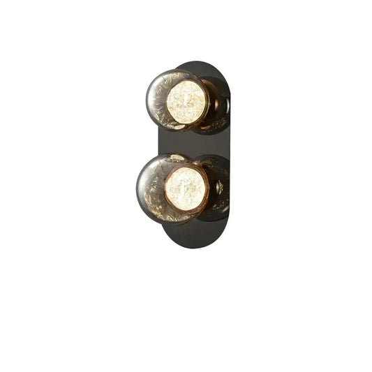 Modern black wall sconce with two spherical textured glass bulbs featuring warm interior lighting for living room wall lights
