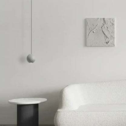 Modern gray and gold cement chandelier with a minimalist gray spherical pendant light on a black cord for dining room decorbites cement chandelier