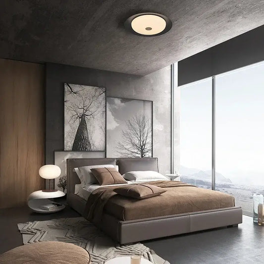 Modern gray leather platform bed with brown throw pillows and blanket under decorbites led ceiling light