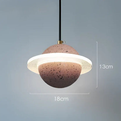 A modern gray and white cement planet pendant light with speckled terracotta sphere and black cord for decorbites decorbites cement planet pendant
