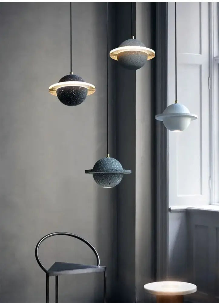 Modern gray and white decorbites cement planet pendant light with speckled ceramic and glowing gold rings for bedroom decor