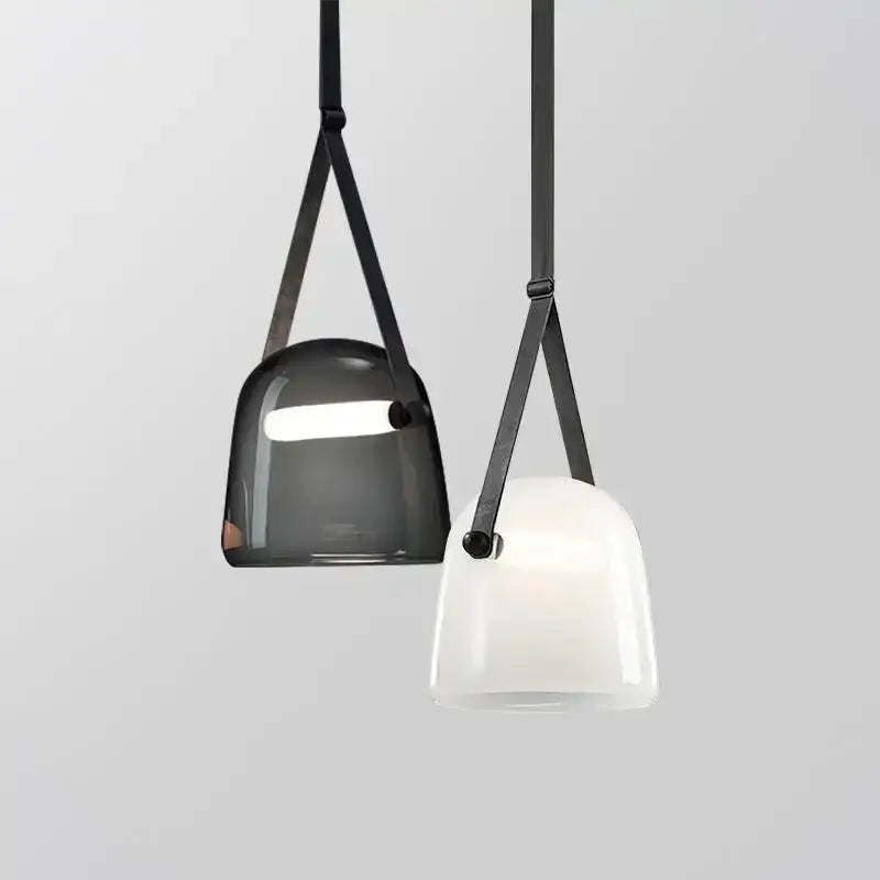 Two modern decorbites glass chandelier pendant lights in translucent gray and opaque white with black leather straps