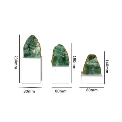 Three green aventurine geode specimens mounted on white bases as modern green agate crystal stone bookends