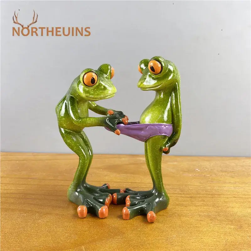 Modern green and orange leggy frog couple resin figurine holding a purple belt for living room decor by decorbites
