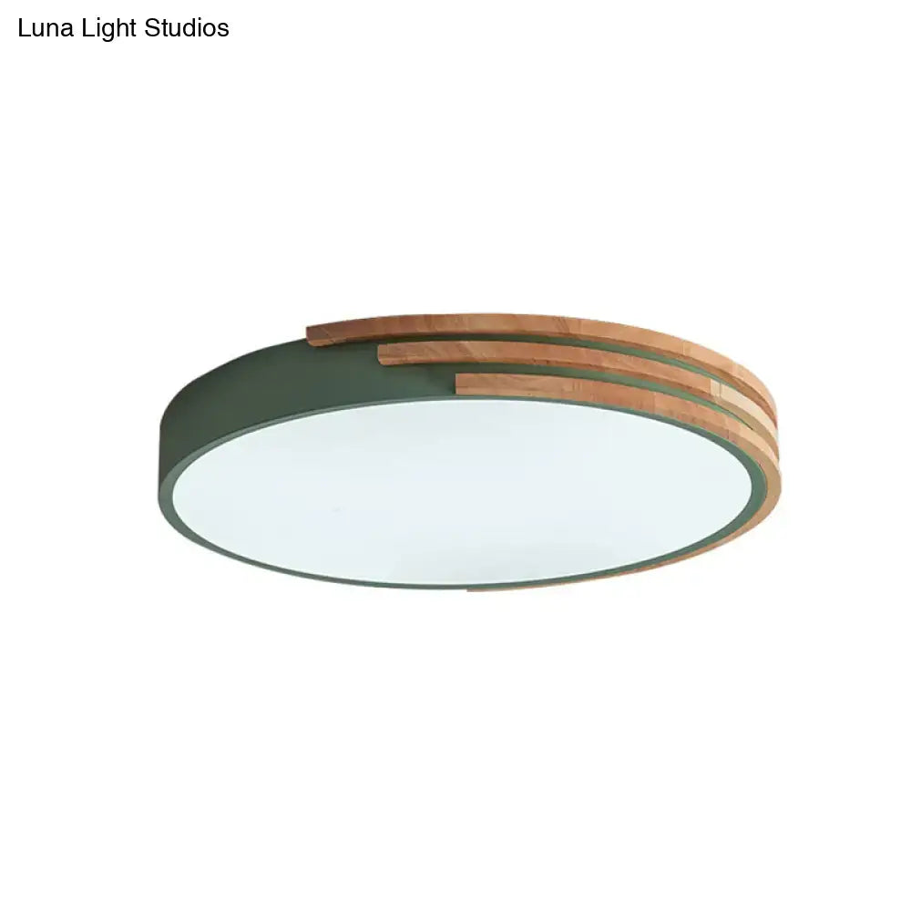 Modern circular decorbites flush mount ceiling light with matte green metal frame and layered natural wood slats