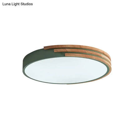 Modern circular decorbites flush mount ceiling light with matte green metal frame and layered natural wood slats