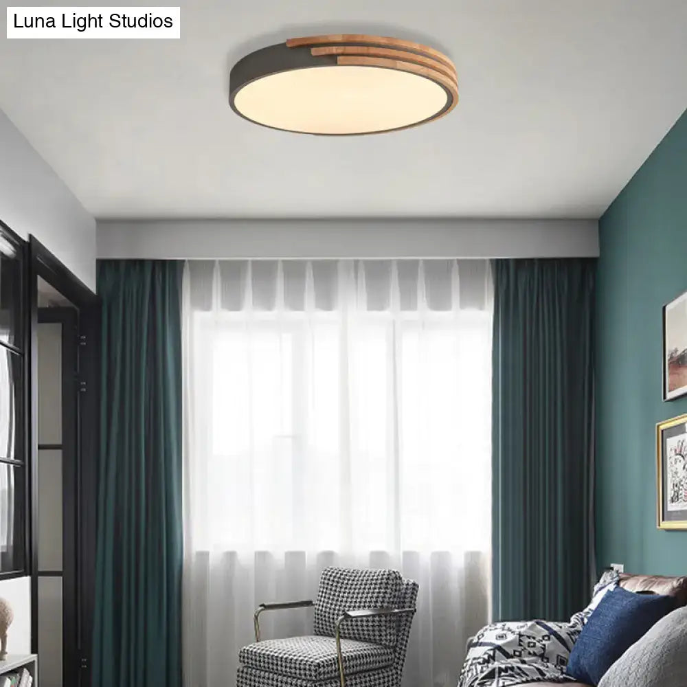 Modern round flush mount ceiling light with a dark metal frame and three wooden concentric rings by decorbites
