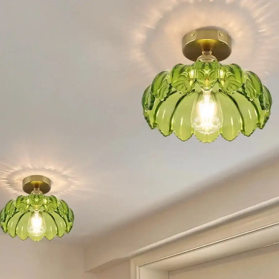 Modern green glass leaf flush mounted ceiling light with brass hardware designed as a banana-shaped glass flush mounted ceiling fixture