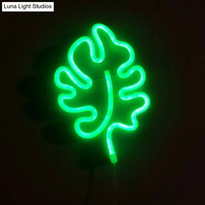 A modern itty bitty green leaf neon sign bedroom wall light with remote control glowing brightly
