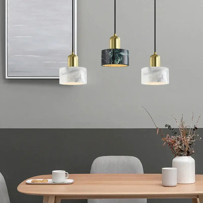 Three modern pendant lights with decorbites green marble and gold-finished metal for dining room decor