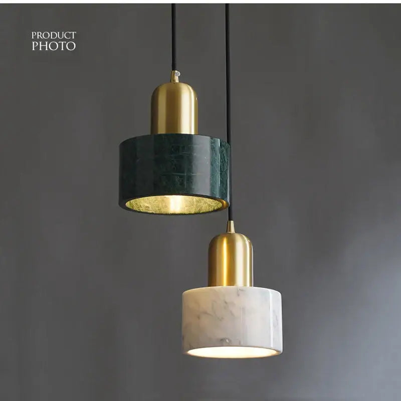 Two modern pendant lights with green marble and white veined marble shades feature polished brass accents for dining room decorbites green marble