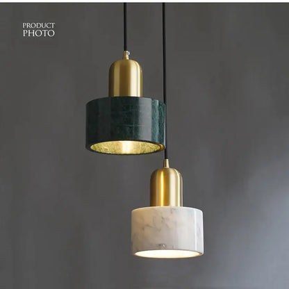 Two modern pendant lights with green marble and white veined marble shades feature polished brass accents for dining room decorbites green marble