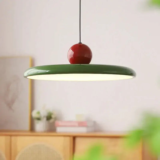 A modern pendant light with a glossy green saucer shade and red accent, perfect for decorbites cream wind dining rooms