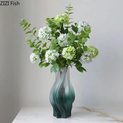 A modern decorbites green ripple glass vase in teal with hydrangeas and eucalyptus for living room decor