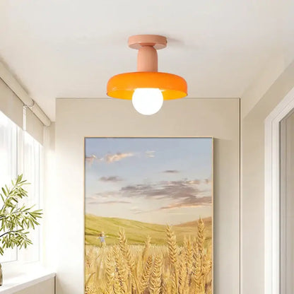 A modern flush-mount ceiling light with a matte peach stem and orange shade for decorbites colorful glass pendant lights