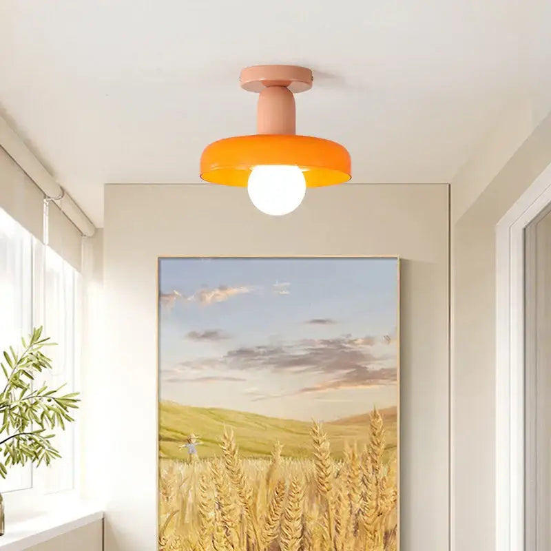 A modern flush-mount ceiling light with a matte peach stem and orange shade for decorbites colorful glass pendant lights