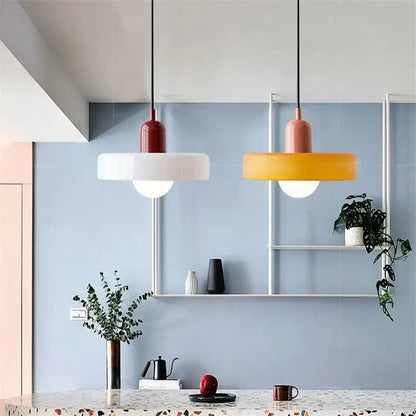 Two modern pendant lights with matte red and orange shades complement decorbites colorful glass pendant dining room decor