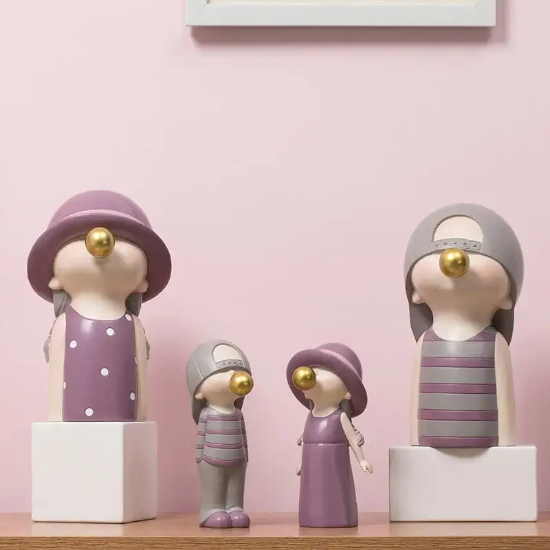Modern green and white polka dot bubble gum blowing resin figurines in purple and gray with gold bubble noses for living room