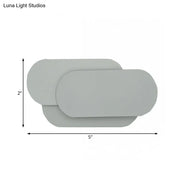 Modern grey oval metal sconce with overlapping panels for bedroom led wall light illumination