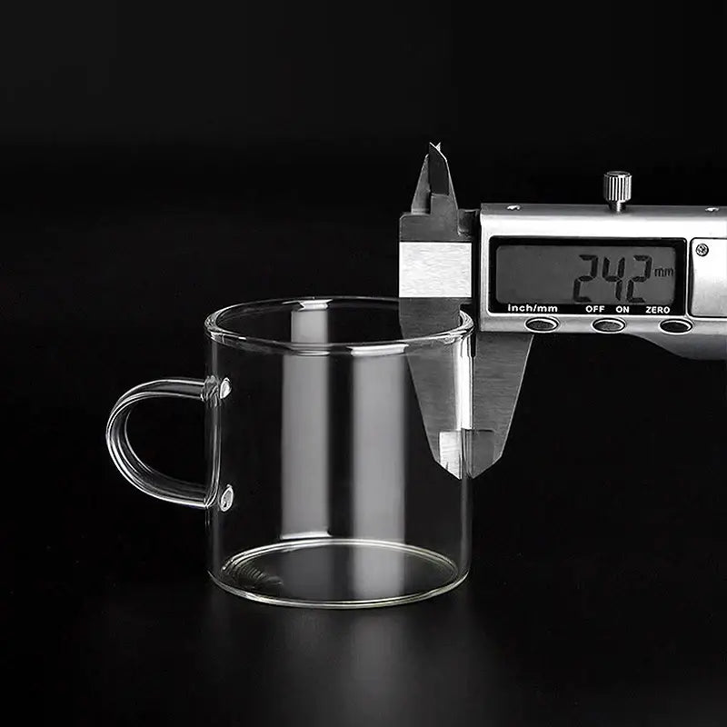 Clear glass tea cup from a modern heat resistant cup set with transparent handle and smooth rounded edges for dining room use
