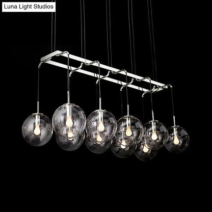 Modern chrome-finished chandelier with seven clear glass globes for stylish island lighting with smoke glass accents