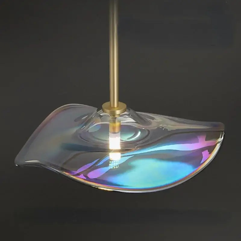 Modern pendant lamp with iridescent blue and purple glass plated shade suspended by brass rod for kitchen lighting